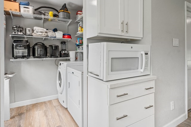 washroom featuring light wood-type flooring, laundry area, baseboards, and independent washer and dryer