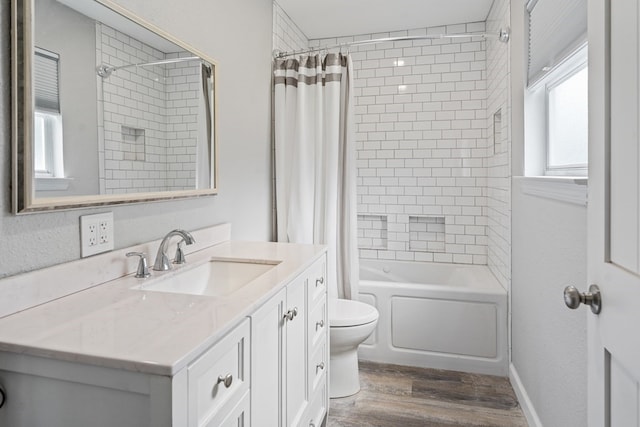 bathroom with toilet, wood finished floors, vanity, and shower / bathtub combination with curtain