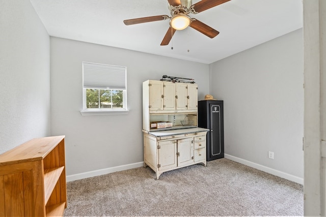 interior space featuring ceiling fan and light colored carpet