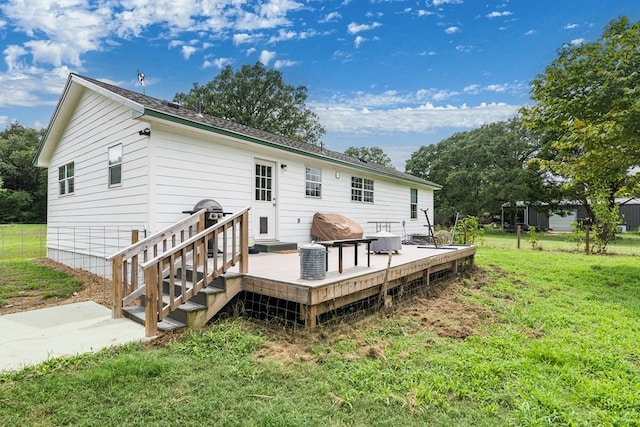 rear view of house featuring a deck and a lawn