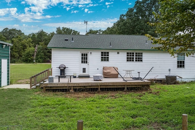 rear view of house featuring a wooden deck, a lawn, and cooling unit