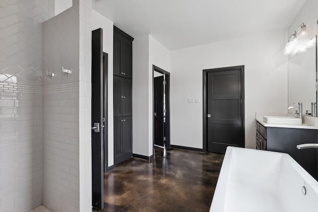 bathroom featuring concrete floors, vanity, and a tub to relax in