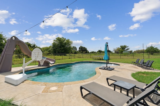 view of swimming pool with a water slide, a yard, and a patio area