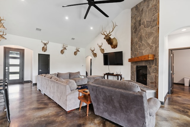 living room featuring a stone fireplace, ceiling fan, and high vaulted ceiling