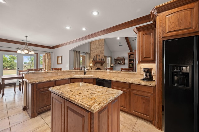 kitchen with lofted ceiling, light stone countertops, a sink, a center island, and black appliances