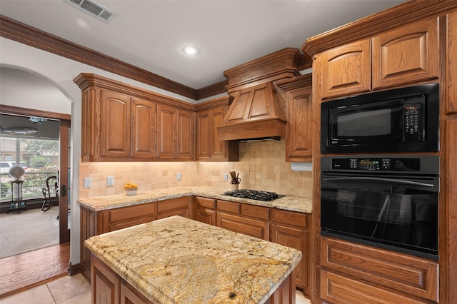 kitchen featuring black appliances, visible vents, decorative backsplash, and light stone counters