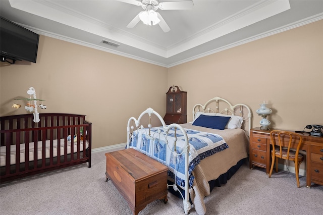 carpeted bedroom with crown molding, a raised ceiling, visible vents, and a ceiling fan