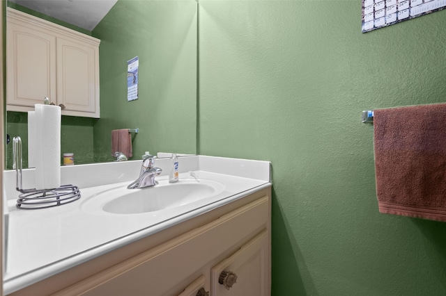 bathroom featuring a textured wall and vanity