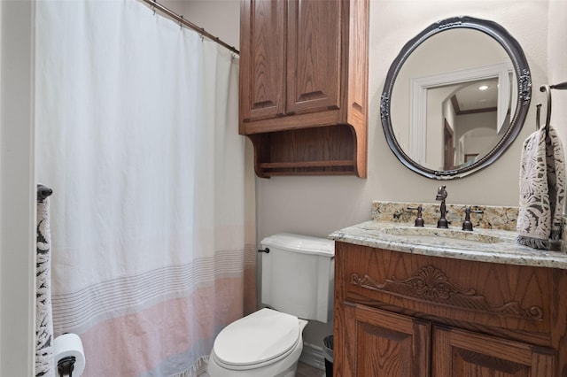 bathroom featuring curtained shower, vanity, and toilet