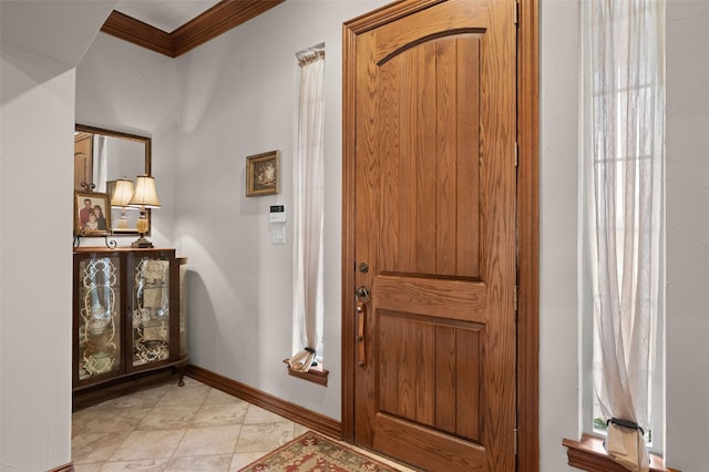 foyer entrance with baseboards and crown molding