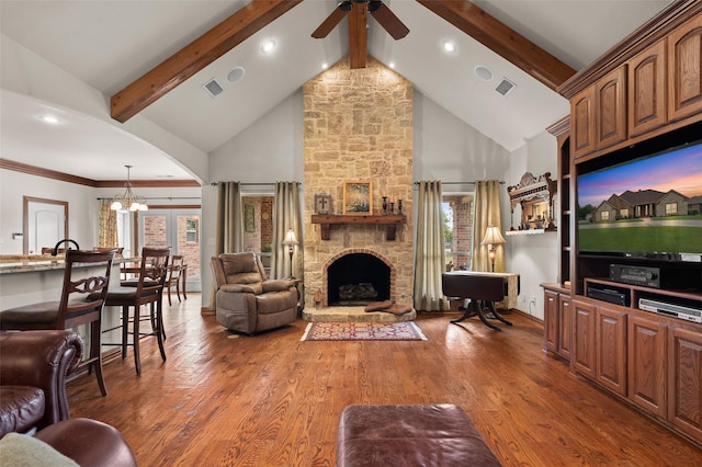 living room featuring plenty of natural light, a fireplace, beamed ceiling, and wood finished floors