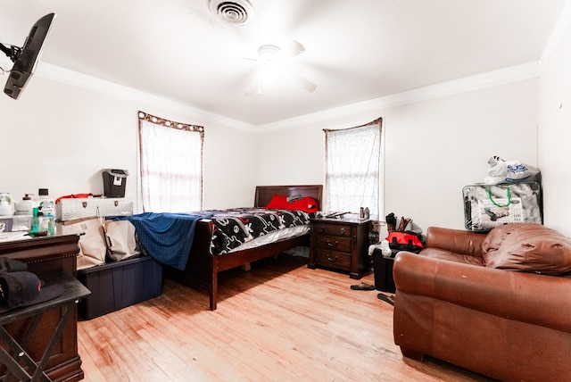 bedroom with crown molding, ceiling fan, and light hardwood / wood-style floors