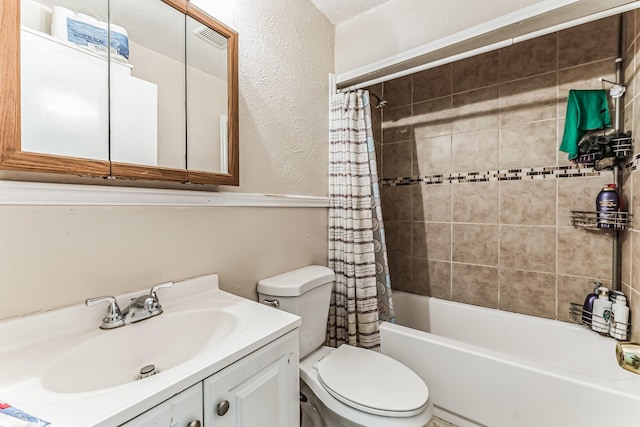 bathroom featuring visible vents, shower / bath combo with shower curtain, toilet, vanity, and a textured wall