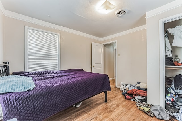 bedroom with hardwood / wood-style flooring and crown molding