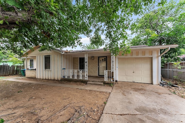 single story home with a garage, board and batten siding, driveway, and fence