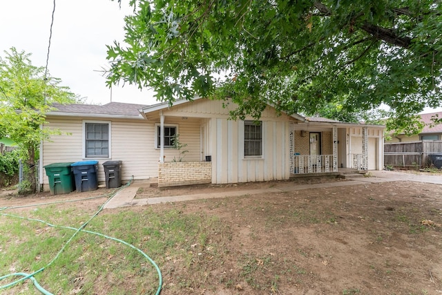 view of front of house featuring driveway, a porch, an attached garage, and fence