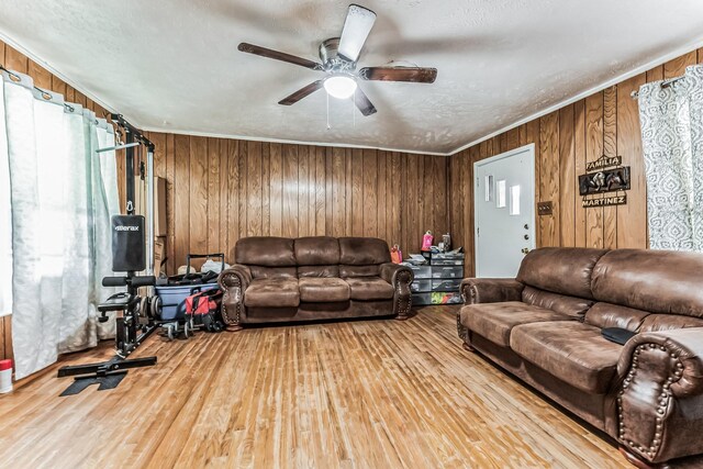 living area featuring ornamental molding, ceiling fan, and wood finished floors