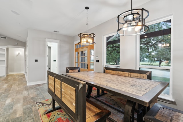 dining area with lofted ceiling, wood-type flooring, and an inviting chandelier