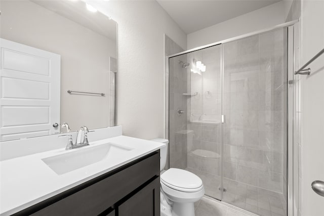 bathroom with vanity, toilet, a shower with door, and tile patterned floors