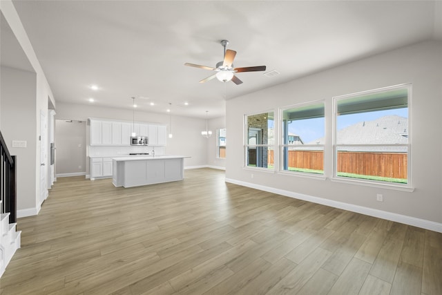 unfurnished living room featuring ceiling fan and light wood-type flooring