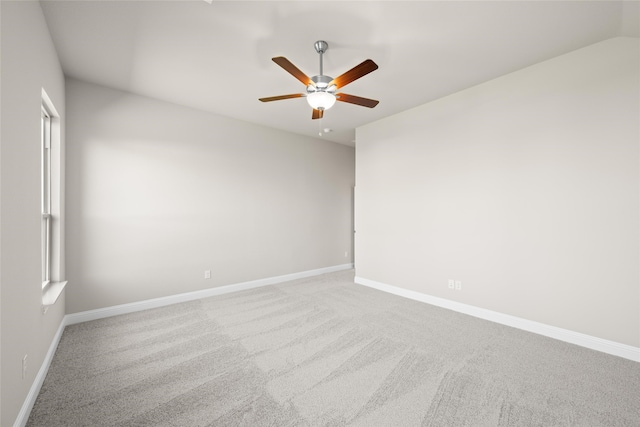 empty room with lofted ceiling, ceiling fan, and carpet floors