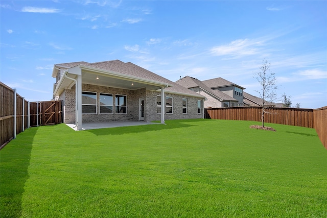 back of house featuring a patio and a yard