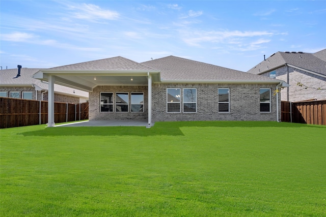 back of house with a lawn and a patio