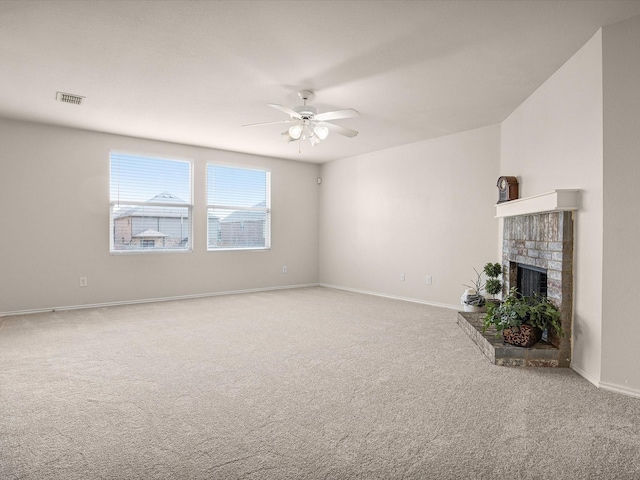 unfurnished living room featuring ceiling fan, a fireplace, and carpet floors