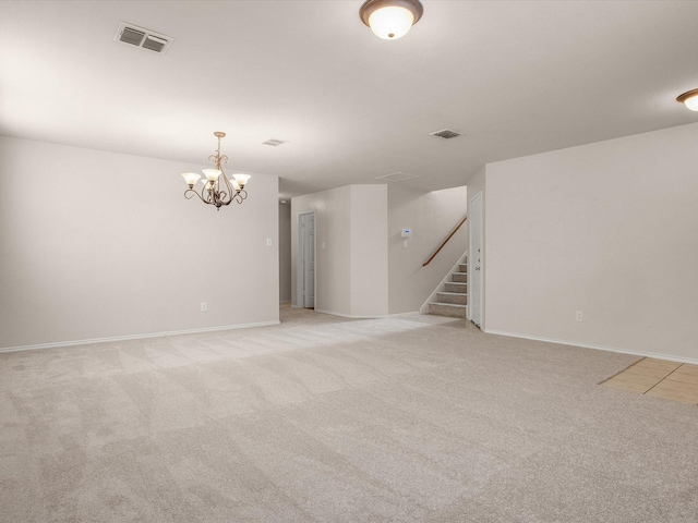 carpeted empty room with a chandelier