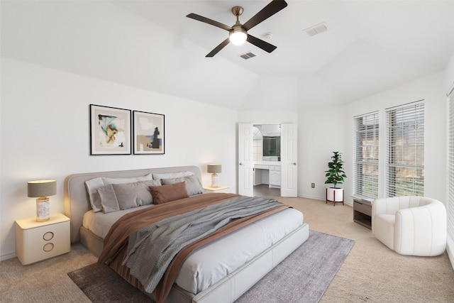 carpeted bedroom featuring vaulted ceiling, ceiling fan, and connected bathroom