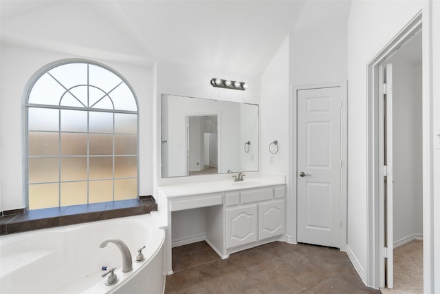 bathroom with a bathtub, lofted ceiling, and vanity