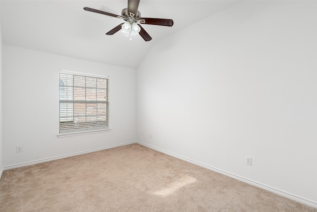 empty room featuring lofted ceiling, ceiling fan, and light colored carpet