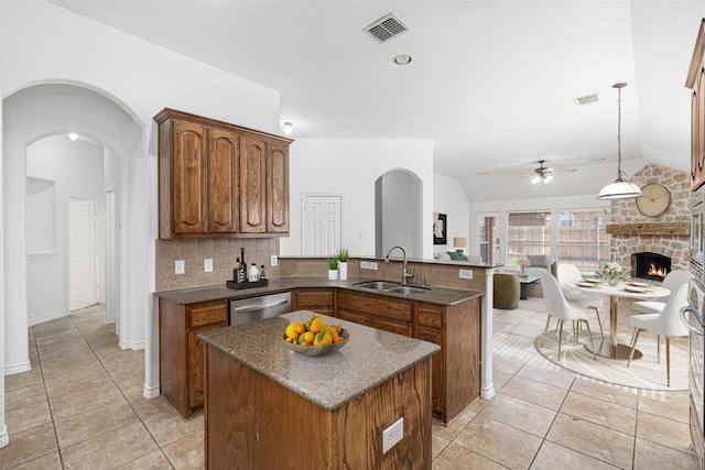 kitchen with sink, stainless steel dishwasher, ceiling fan, and vaulted ceiling