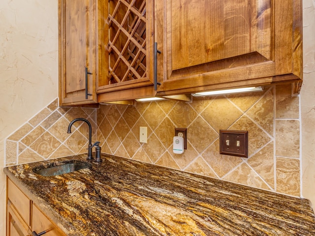 kitchen with sink, tasteful backsplash, and dark stone counters