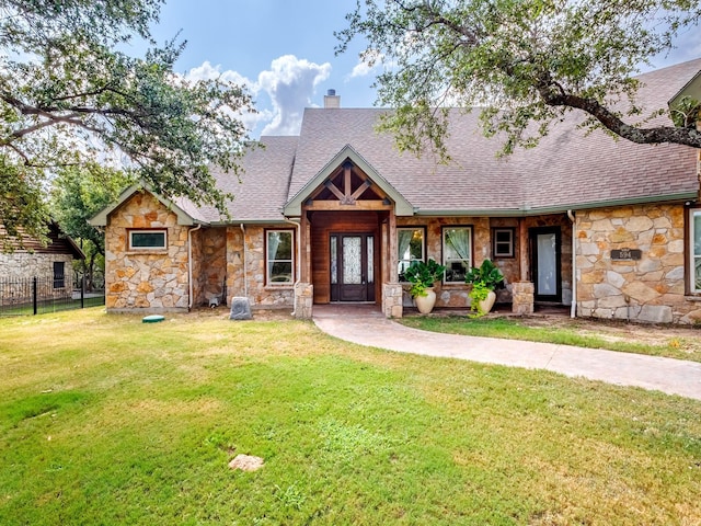 view of front of property featuring a front yard, roof with shingles, fence, and a chimney