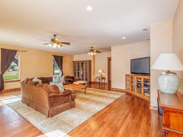 living room featuring hardwood / wood-style floors and ceiling fan