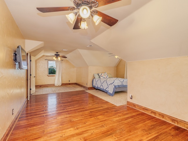 unfurnished bedroom featuring ceiling fan, vaulted ceiling, and light hardwood / wood-style floors