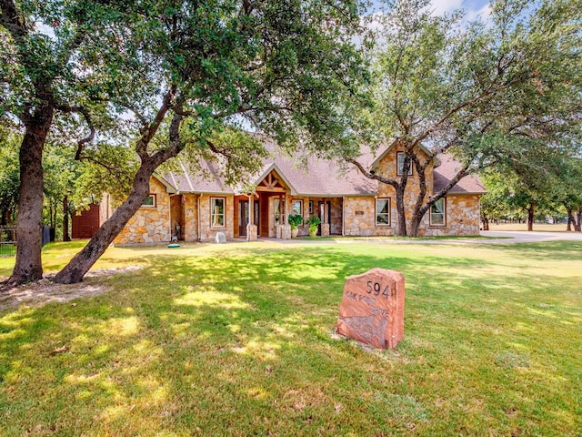 view of front facade with stone siding and a front yard