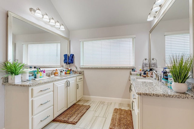 bathroom with vanity, lofted ceiling, and tile patterned floors