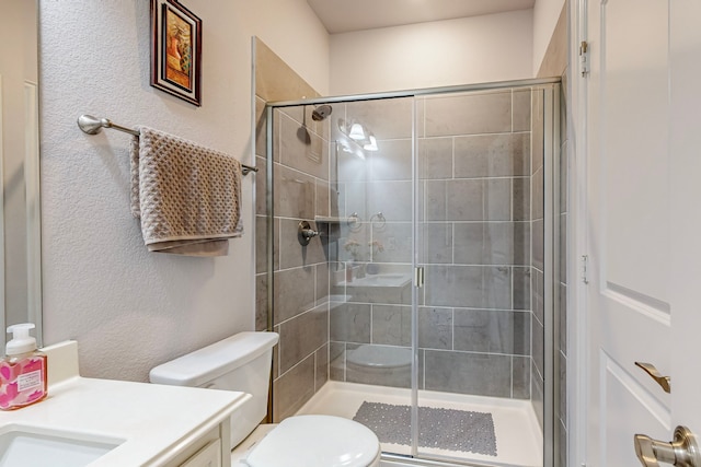 bathroom with vanity, toilet, and a shower with door