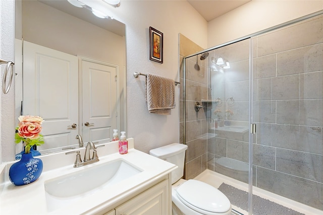 bathroom with walk in shower, toilet, and vanity