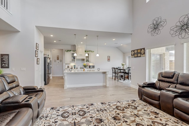 living room featuring light hardwood / wood-style floors and high vaulted ceiling