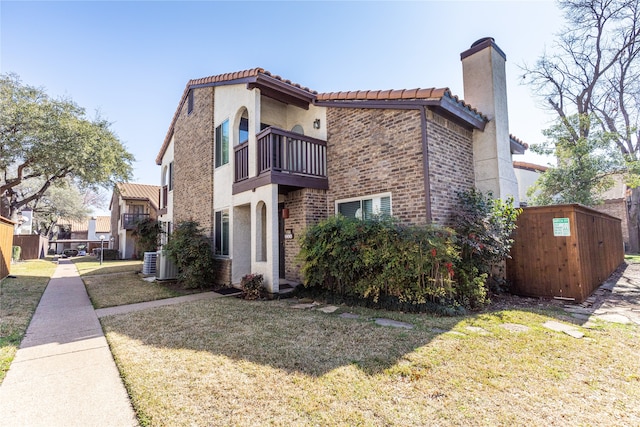 exterior space with a balcony, central air condition unit, and a lawn