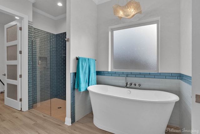 bathroom featuring an inviting chandelier, tile walls, hardwood / wood-style flooring, crown molding, and independent shower and bath