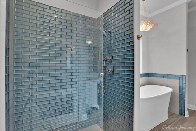 bathroom featuring tile walls, shower with separate bathtub, crown molding, and hardwood / wood-style floors