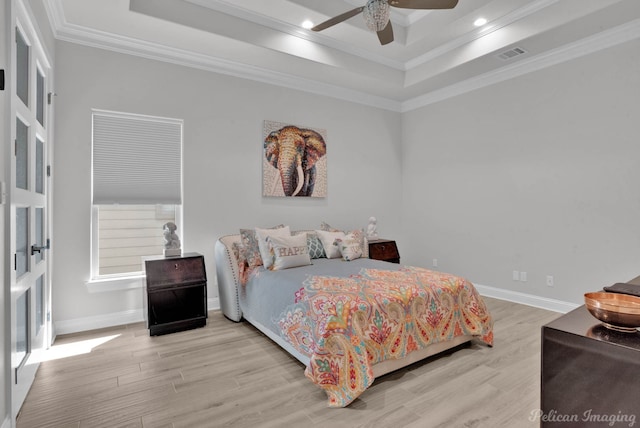 bedroom with a raised ceiling, ceiling fan, crown molding, and light hardwood / wood-style floors