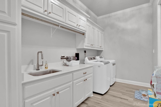 laundry room with washer and dryer, cabinets, crown molding, light hardwood / wood-style flooring, and sink