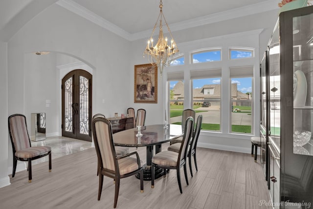 dining space featuring crown molding, light hardwood / wood-style flooring, french doors, and a notable chandelier