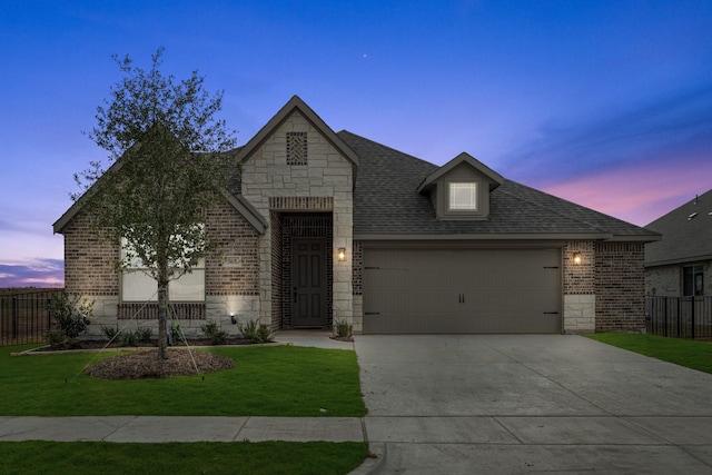 view of front of property with a garage and a yard