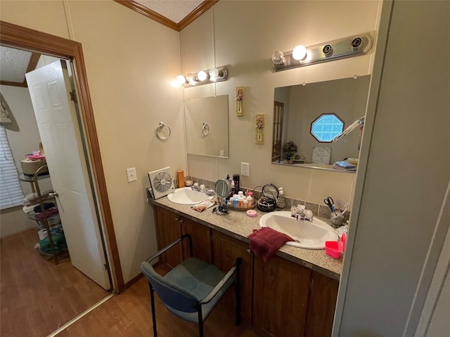 bathroom featuring ornamental molding, wood-type flooring, and double sink vanity